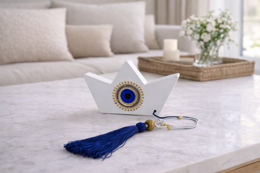 Decorative boat with an evil eye charm a  a blue tassel on a table in a living room