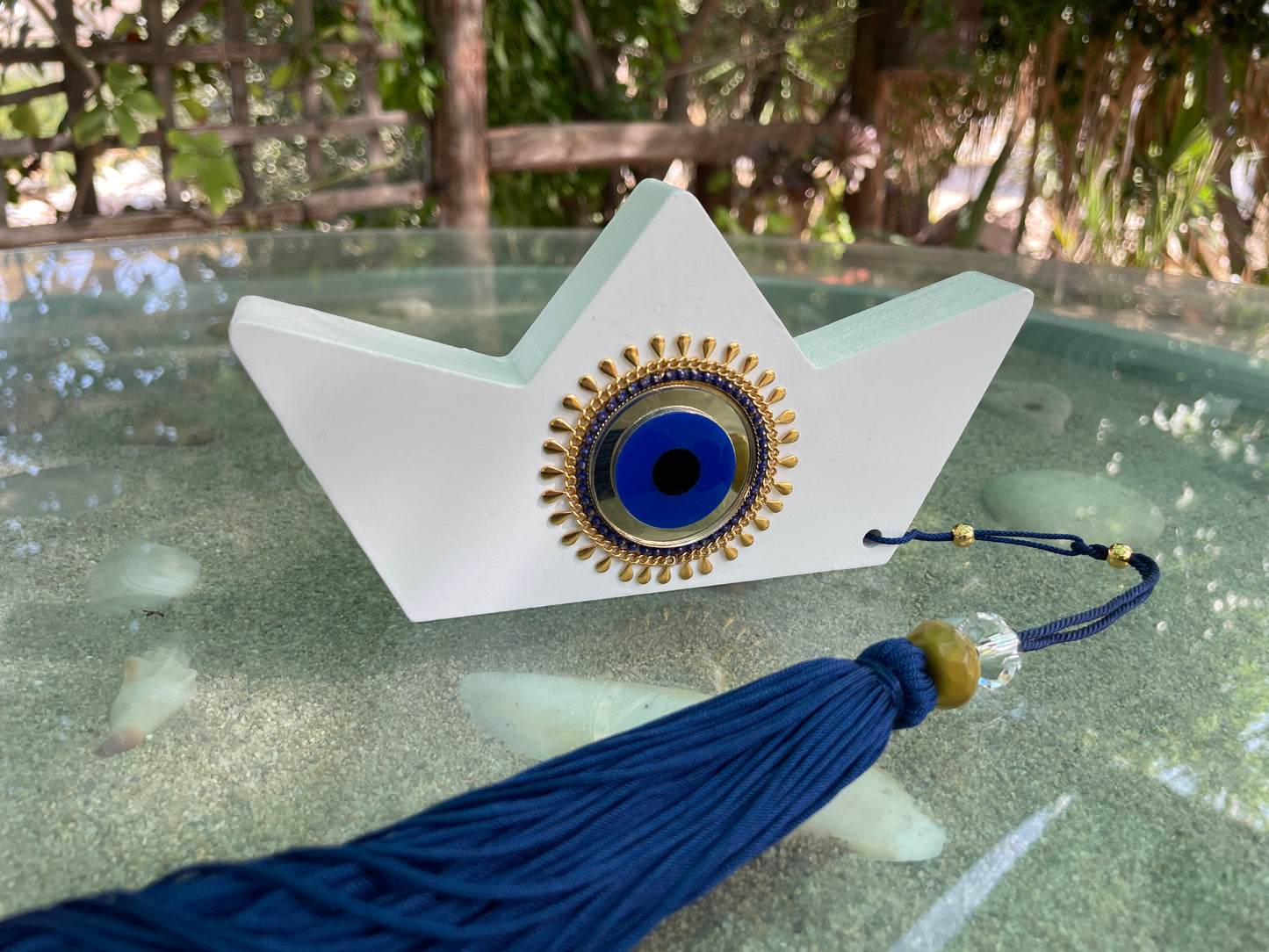 Decorative item with blue tassel on a glass surface