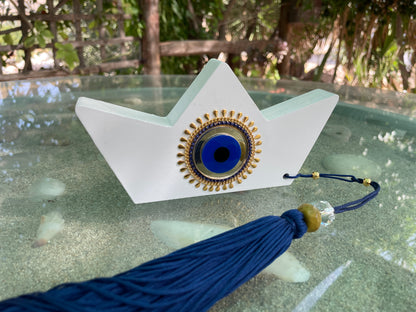 Decorative item with blue tassel on a glass surface
