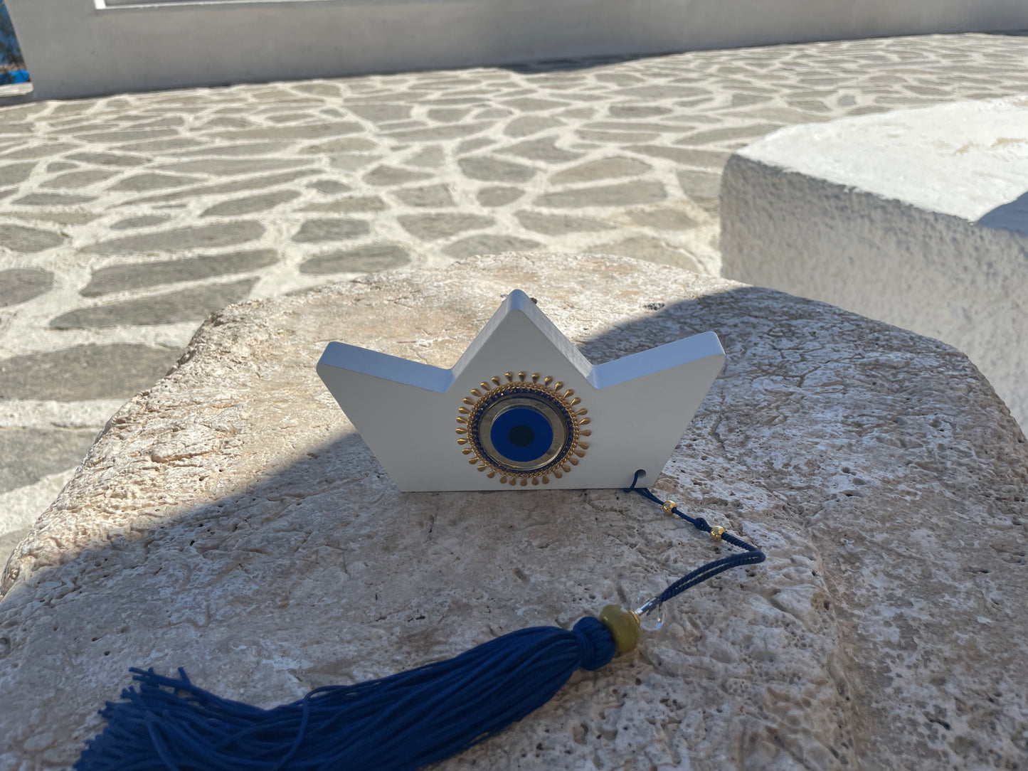 Decorative object with blue tassel on a stone surface