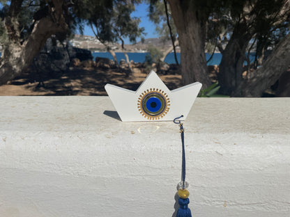 Decorative item resembling a star with a blue center and gold accents on a wooden surface outdoors.