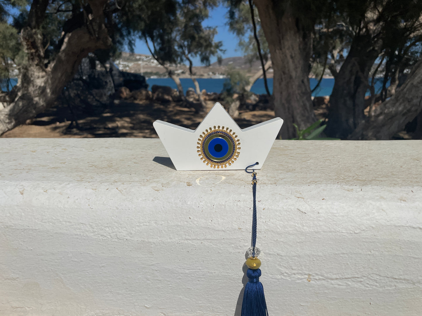 Decorative item with a star-shaped base and blue tassel on a wooden surface.