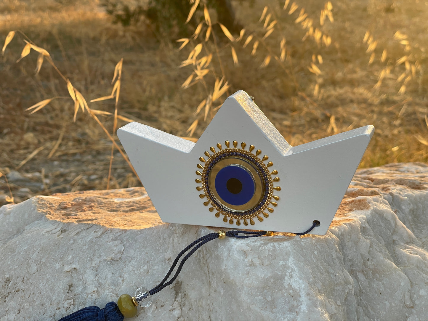 Decorative object with a circular design on a stone surface with grass in the background